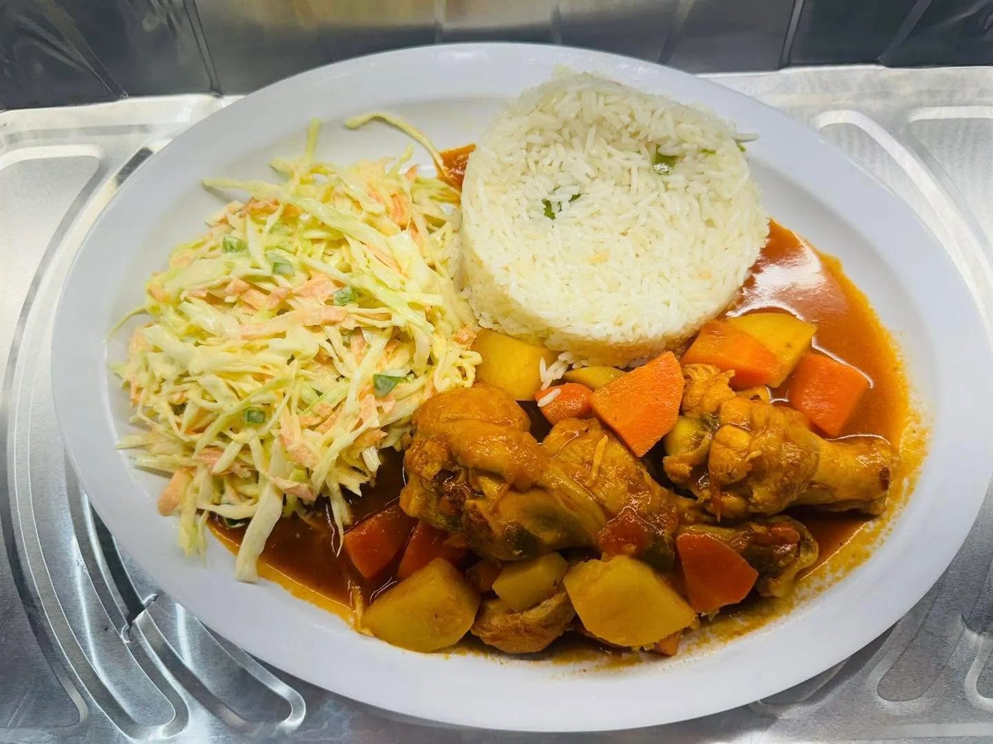 Chicken stew plate with rice and salad