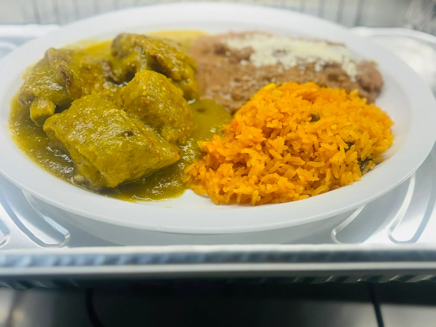 Chicken in green salsa with rice and refried beans