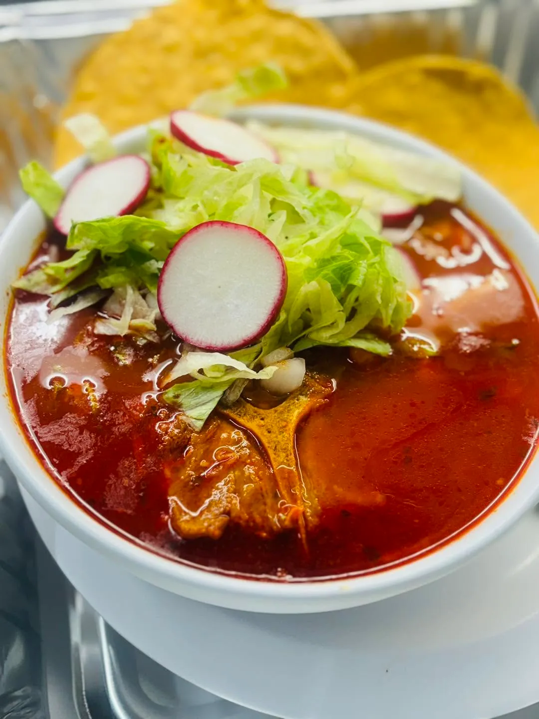 Mexican red chile soup topped with lettuce and radish